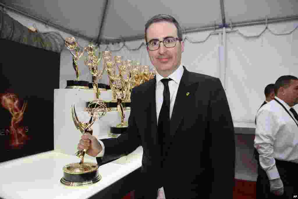 Pembawa acara John Oliver bersama piala Emmy Award yang dimenangkannya.