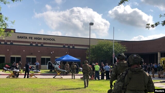 Policías responden a un tiroteo en la escuela secundaria Santa Fe en Texas el viernes, 18 de mayo, de 2018.