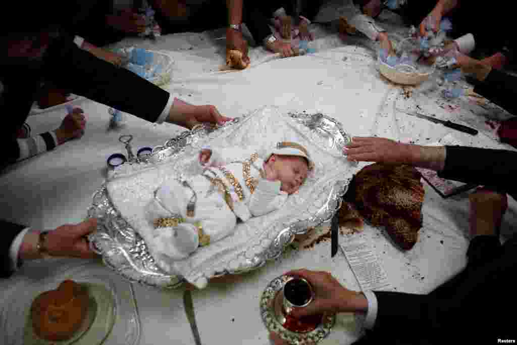 The great-grandson of the spiritual leader of the ultra-Orthodox Jewish Hassidic Lelover dynasty lies on a table during a religious ceremony, called &quot;Pidyon Ha&#39;ben&quot;, or the &quot;redemption of the first-born son&quot;, originating from the biblical story of Moses on Mount Sinai, whereby the father of the baby makes a symbolic offering, including jewellery and sweets, to a Kohen or Jewish priest, in Jerusalem&#39;s neighbourhood of Mea Shearim.