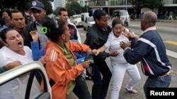 Cuban security personnel detain members of the Ladies in White group during a protest on International Human Rights Day, in Havana, Dec. 10, 2014.