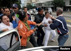 FILE - Cuban security personnel detain members of the Ladies in White group during a protest on International Human Rights Day, in Havana, Dec. 10, 2014.
