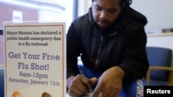 Oddelio Reid fills out paperwork before getting an influenza vaccine injection during a flu shot clinic at Dorchester House, a health care clinic, in Boston, Massachusetts January 12, 2013.