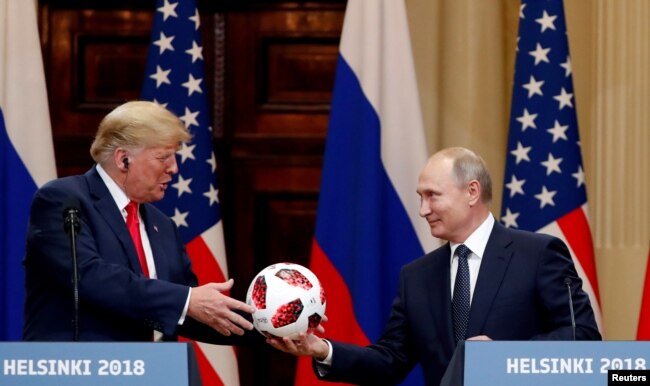 El presidente de EE. UU., Donald Trump, recibe una pelota de fútbol del presidente ruso, Vladimir Putin, mientras celebran una conferencia de prensa conjunta después de su reunión en Helsinki, Finlandia el 16 de julio de 2018. REUTERS / Grigory Dukor.