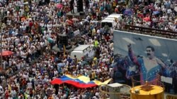 VENEZUELA – Opposition supporters take part in a rally against Venezuela's President Nicolas Maduro next to a poster of him in Caracas, Venezuela, October 26, 2016.