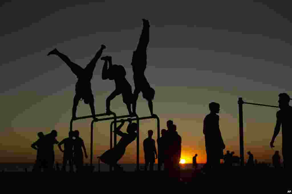 İspanya&rsquo;nın Cadiz kentindeki Victoria plajında halk gün batımında kamuya açık spor alanında spor yapıyor.
