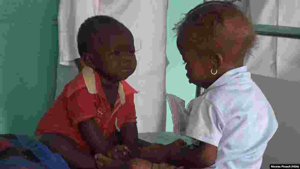 Deux enfants jouent sur un lit au centre régional de santé mère enfant de Diffa, Niger, le 18 avril 2017 (VOA/Nicolas Pinault)