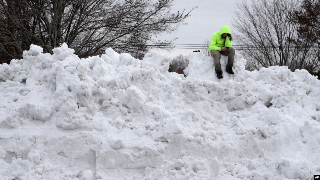 Troy Herrington, sentado sobre una montaña de nieve, espera a su jefe para que lo recoja en Greensboro, Carolina del Norte, luego de limpiar un estacionamiento de un centro comercial.