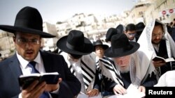 FILE - Ultra-Orthodox Jewish worshippers take part in the priestly blessing prayer on the holiday of Passover at the Western Wall in Jerusalem's Old City, April 13, 2017. 