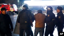 Almaty မြို့မှာ ဆန္ဒပြသူတဦးကို ဖမ်းဆီးခေါ်ဆောင်လာတဲ့ ကာဇက်စတန် ရဲတပ်ဖွဲ့ဝင်များ။ (ဇန်နဝါရီ ၅၊ ၂၀၂၂)