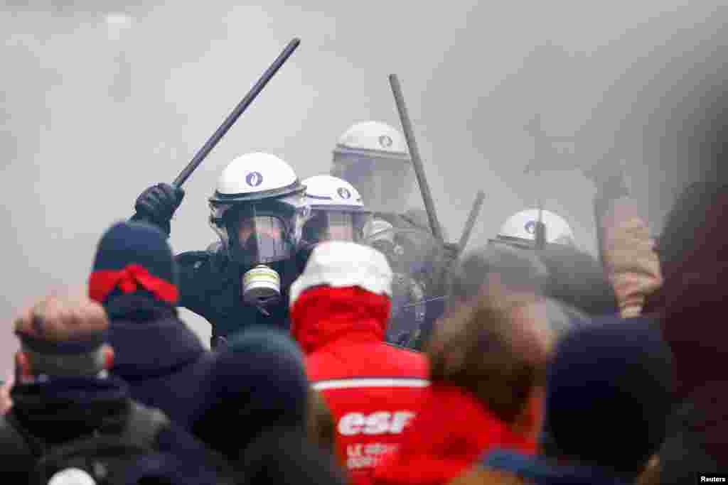 Riot police confront demonstrators at a national strike by workers and trade union members, who are demanding stronger public services in Brussels, Belgium.