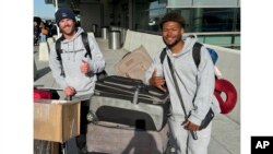 FILE—This image courtesy of Rebecca Higbee shows Marcel Malanga, right, and Tyler Thompson posing for a photo at the Salt Lake City International Airport on April 10, 2024, before departing for Africa.