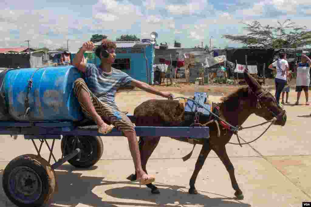 Un joven lleva un tanque de agua en camino al asentamiento La Pista. Se estima que existen 180 cruces informales a lo largo de la frontera, una zona considerada de las m&#225;s pobres de Colombia y Venezuela.