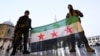 Rebel fighters pose as they hold a Syrian opposition flag inside the Umayyad Mosque, in Damascus