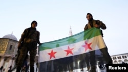 Anggota pasukan pemberontak membentangkan bendera oposisi Suriah di Masjid Umayyad di Damaskus, pada 9 Desember 2024. (Foto: Reuters/Amr Abdallah Dalsh)