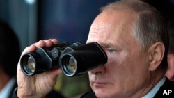 Президент Росії Володимир Путін у бінокль спостерігає за військовими навчаннями поблизу Оренбурга, Росія, 20 вересня 2019. Фото: Прес-служба Кремля, AP