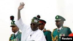 FILE — Nigerian President Bola Tinubu waves at a crowd, during his swearing-in ceremony in Abuja, May 29, 2023. 