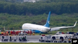 A Boeing passenger plane from China, a Xiamen Air, sits on the grassy portion of the runway of the Ninoy Aquino International Airport after it skidded off the runway while landing, Aug. 17, 2018 in suburban Pasay city southeast of Manila, Philippines. All the passengers and crew of Xiamen Air Flight 8667 were safe and were taken to an airport terminal, where they were given blankets and food before being taken to a hotel. 