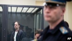 (FILE) Wall Street Journal reporter Evan Gershkovich stands in a glass cage in a courtroom at the First Appeals Court of General Jurisdiction in Moscow, Russia, Tuesday, April 23, 2024.