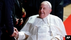 El papa Francisco estrecha la mano de funcionarios después de su reunión para la ceremonia de despedida del Papa en el aeropuerto de Ajaccio, en la isla francesa de Córcega, el 15 de diciembre de 2024.