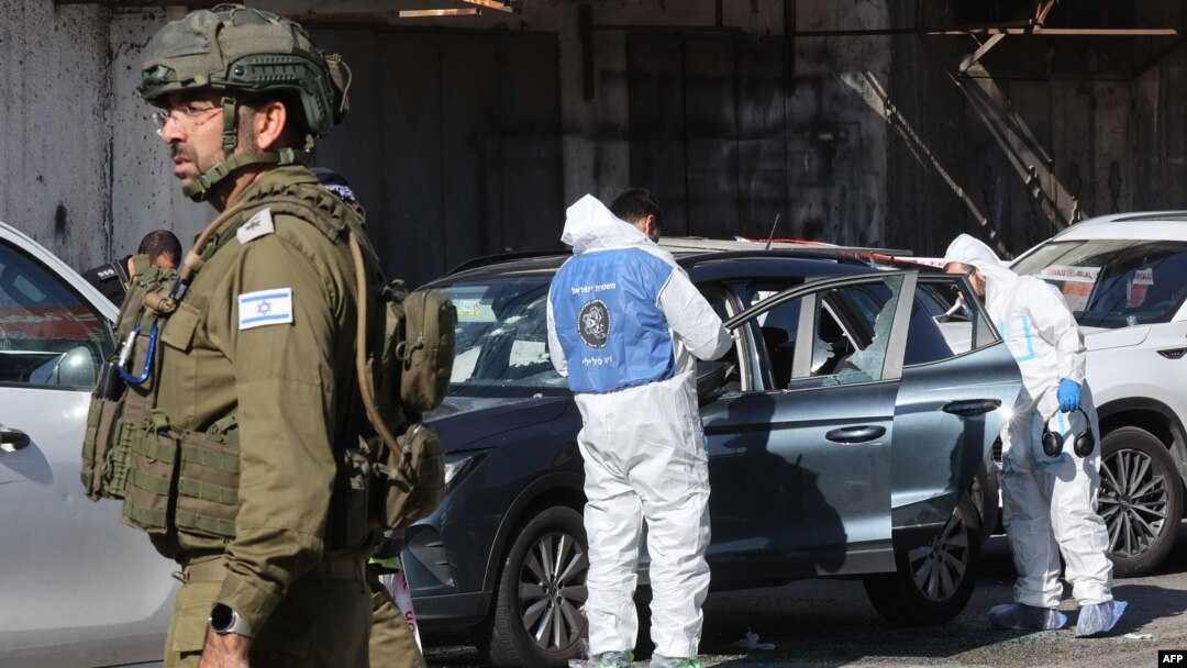 TOPSHOT - Tim penyelamat dan pasukan keamanan Israel bekerja di lokasi serangan di dekat desa al-Funduq, di Tepi Barat yang diduduki, pada 6 Januari 2025. (GIL COHEN-MAGEN/AFP)