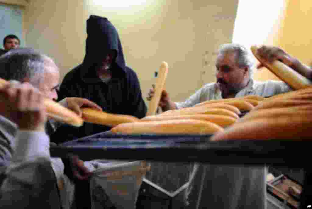 A Libyan man (C) receives his bread ration from a bakery in Misrata on April 23, 2011 as intense fighting gripped the city after Moammar Gadhafi's regime gave its army an "ultimatum" to take it back. (AFP image)