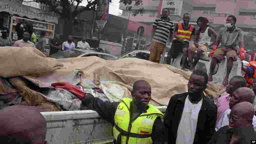 Ana sanya gawarwakin mutanen da suka mutu a fashewar wani abu a gidan mai cikin mota a Accra, babban birnin Ghana, alhamis 4 Yuni, 2015. Ambaliyar da aka yi ta yi gaba da man fetur zuwa wata wutar dake kunne a kusa da gidan man, wutar ta sanya wani abu yayi bindiga, ta kuma watsu zuwa gine-ginen dake kusa da wannan gidan mai. Mutane masu yawa suka mutu.