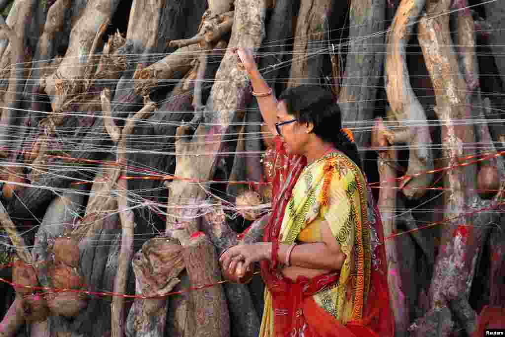 Seorang penganut agama Hindu memanjatkan doa di depan api unggun selama ritual yang dikenal sebagai "Holika Dahan," yang merupakan bagian dari perayaan festival Holi di pinggiran Ahmedabad, India. (Reuters) 