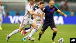 Netherlands' Arjen Robben, right, is challenged by Spain's Fernando Torres during the World Cup match between Spain and the Netherlands, June 13, 2014.