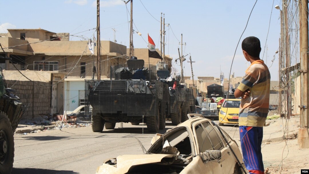 Ljudi posmatraju iračke snage kako odlaze ka poslednjim delovima grada koje drže militanti Islamske države u Mosulu, Irak, 1. jun 2017. (H. Murdock/VOA)