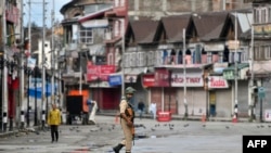 A security personnel patrols on a deserted road of the Lal Chowk area in Srinagar, Aug. 19, 2019. 