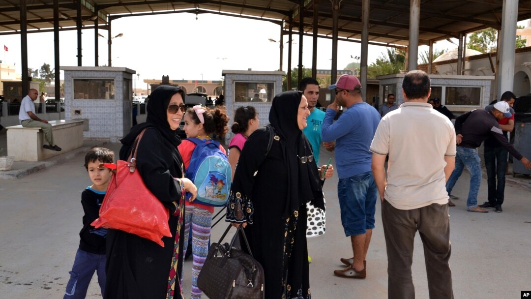Perempuan Libya menyeberang ke Tunisia di perbatasan Ras Ajdir antara Libya dan Tunisia.