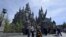 Guests pose before they enter Hogwarts School during a soft opening and media tour of "The Wizarding World of Harry Potter" theme park at the Universal Studios Hollywood in Los Angeles, California March 22, 2016. 