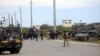 Italian and Somali security forces are seen near armored vehicles at the scene of an attack on a Italian military convoy in Mogadishu, Somalia, Sept. 30, 2019.