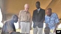 Feb. 11, 2010. Terekeka, Southern Sudan. Former U.S. President and Carter Center Founder Jimmy Carter watches while Garbino, a young farmer with a Guinea worm disease, receives free treatment from a village volunteer trained by The Carter Center in partne