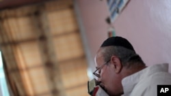 FILE - In this Aug. 29, 2009, photo, Zebulon Simentov, the last known Jew living in Afghanistan and the caretaker and sole member of Afghanistan's only working synagogue, kisses his prayer book while observing Shabbat in his Kabul home. 