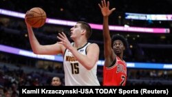 Nikola Jokić u duelu sa košarkašem Čikago Bulsa Džastinom Holidejom (Foto. Reuters/Kamil Krzaczynski-USA TODAY Sports) 