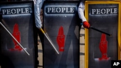 FILE - Anti-coup demonstrators hold makeshift shields during a protest in Yangon, Myanmar, March 9, 2021.