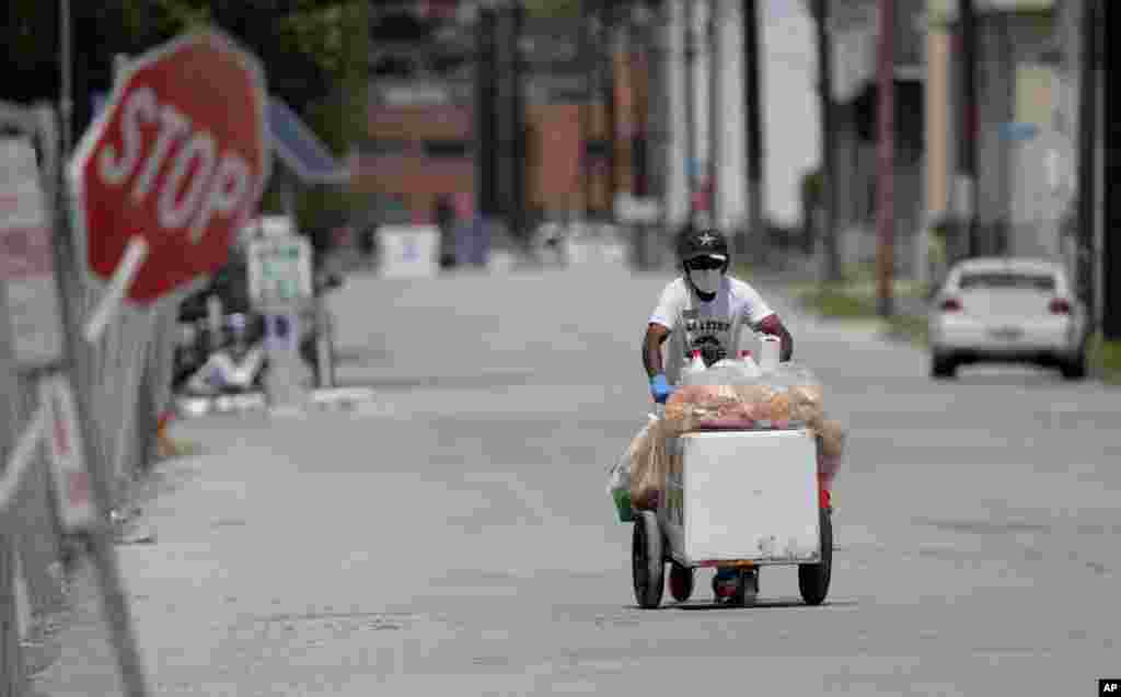 Texas: Un vendedor de helados empuja su carrito a través de una calle desolada en San Antonio. San Antonio permanece bajo una orden de quedarse en casa.