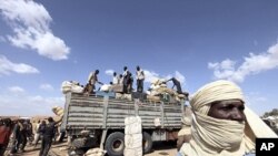 Immigrants, who are fleeing the unrest in Libya, unload their belongings in Agadez northen Niger September 15, 2011.