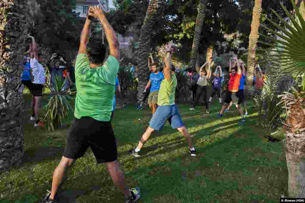 A group of Egyptian athletes gathers in a square to work out before sunset. Athletes find that working out during the last hour of fasting is better for burning more calories than normal.