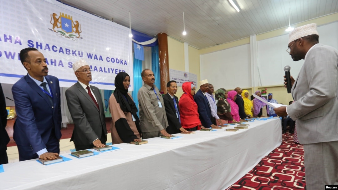 Anggota baru parlemen Somalia menempatkan tangan mereka pada salinan Al-Qur'an saat dilantik di kamp pelatihan Sekolah Polisi di Mogadishu, 27 Desember 2016. (REUTERS/Feisal Omar).