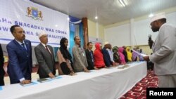 Anggota baru parlemen Somalia menempatkan tangan mereka pada salinan Al-Qur'an saat dilantik di kamp pelatihan Sekolah Polisi di Mogadishu, 27 Desember 2016. (REUTERS/Feisal Omar).