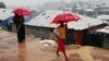 Pengungsi Rohingya membawa payung saat hujan deras di kamp Kutupalong di Cox's Bazar, Bangladesh, 4 Juli 2018.(REUTERS/Mohammad Ponir Hossain)