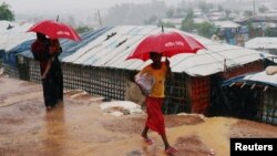 Pengungsi Rohingya membawa payung saat hujan deras di kamp Kutupalong di Cox's Bazar, Bangladesh, 4 Juli 2018.(REUTERS/Mohammad Ponir Hossain)