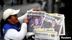 En la imagen de archivo una mujer vende periódicos con fotografías del entonces candidato presidencial Alejandro Giammattei, actual presidente de Guatemala.
