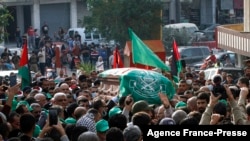 Mourners, including fighters, take part in a funeral procession for Hamza Ibrahim Shahin, a member of the Hamas movement ruling in the Gaza Strip, in the Burj al-Shamali camp for Palestinian refugees near the southern Lebanese coastal city of Tyre, Dec. 12, 2021.
