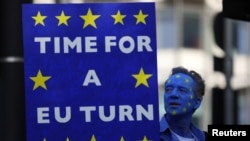 A protester holds a banner before an anti-Brexit demonstration, in central London, Britain, Oct. 20, 2018.