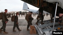 FILE - Marines board a KC-130J Hercules aircraft at the U.S. Futenma airbase on the Japanese island of Okinawa.