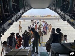 En esta foto proporcionada por el Ministerio de Defensa español y tomada en Kabul, Afganistán, personas a bordo de un avión A400 de la fuerza aérea española como parte de un plan de evacuación en el aeropuerto de Kabul, el 18 de agosto de 2021.