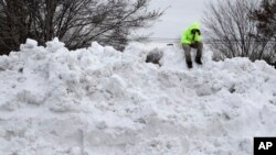 Troy Herrington, sentado sobre una montaña de nieve, espera a su jefe para que lo recoja en Greensboro, Carolina del Norte, luego de limpiar un estacionamiento de un centro comercial.